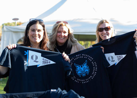 Three alumni pose for a picture during a Quinnipiac reunion event